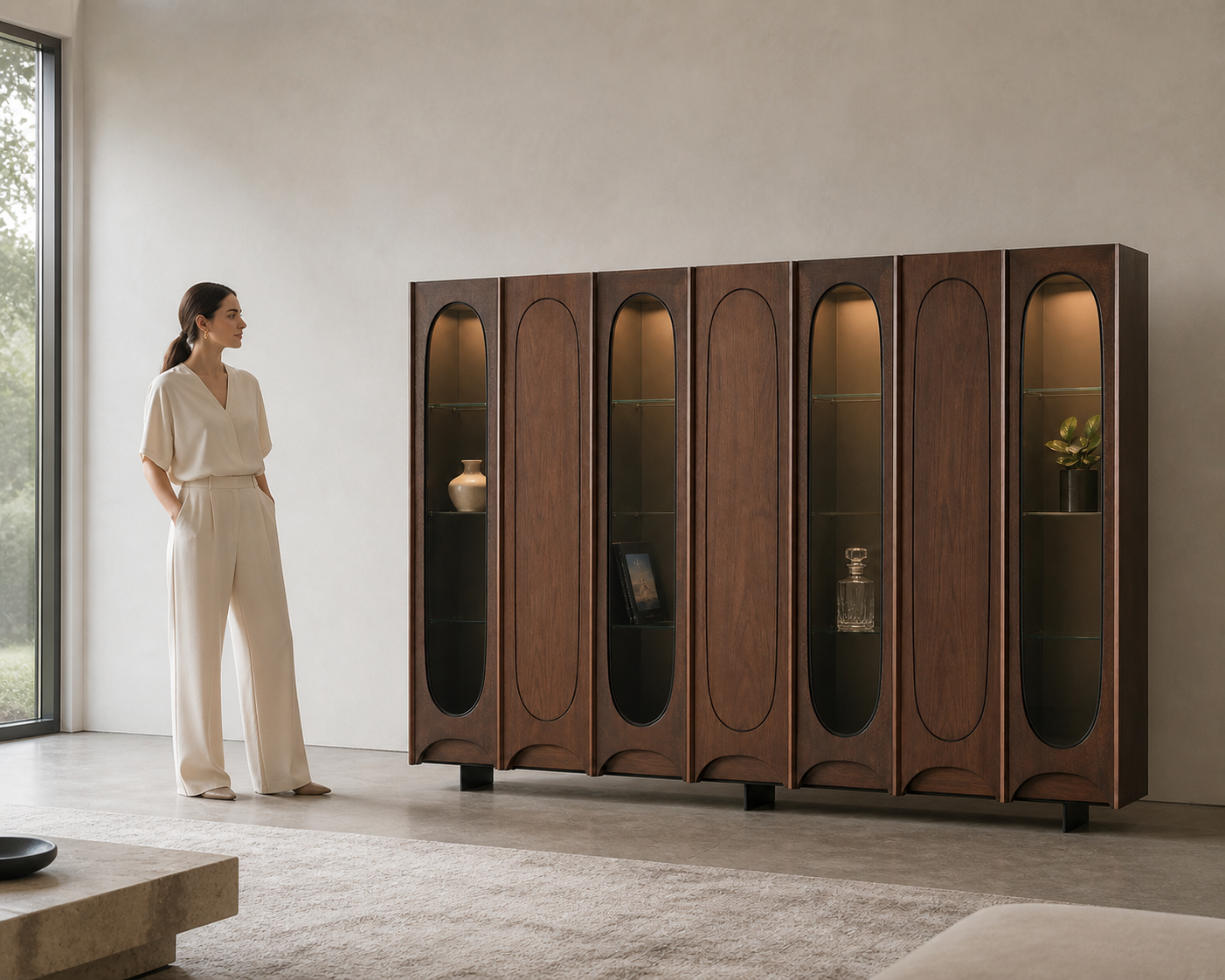 AUTHË v2 human scale — Colonnade Cabinet with one person establishing the true scale of seven walnut bays with alternating smoked-glass apertures and four recessed bronze feet